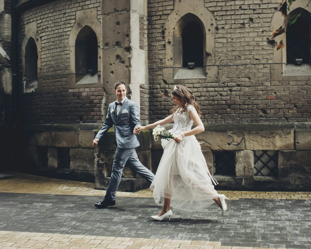 Beautiful emotional wedding couple running and smiling in european city. Provence wedding